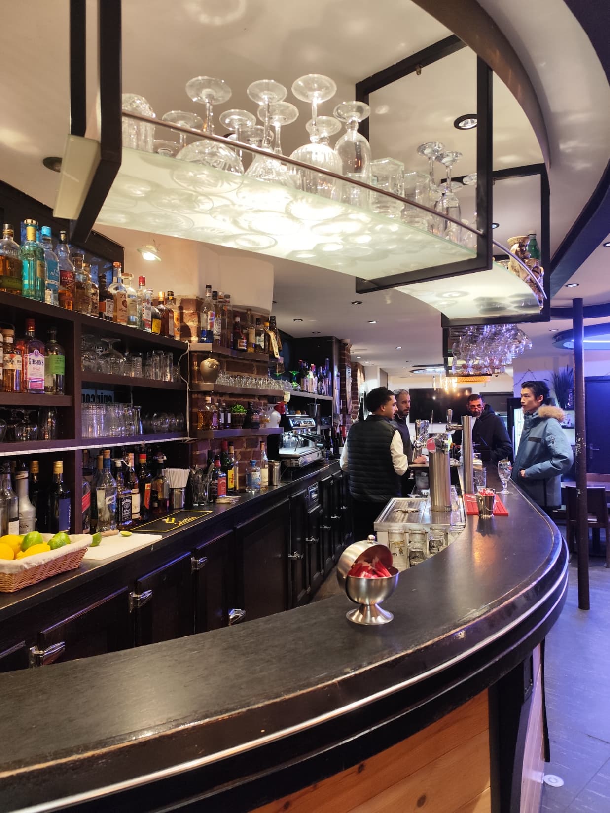 Comptoir du bar avec verres suspendus et bouteilles